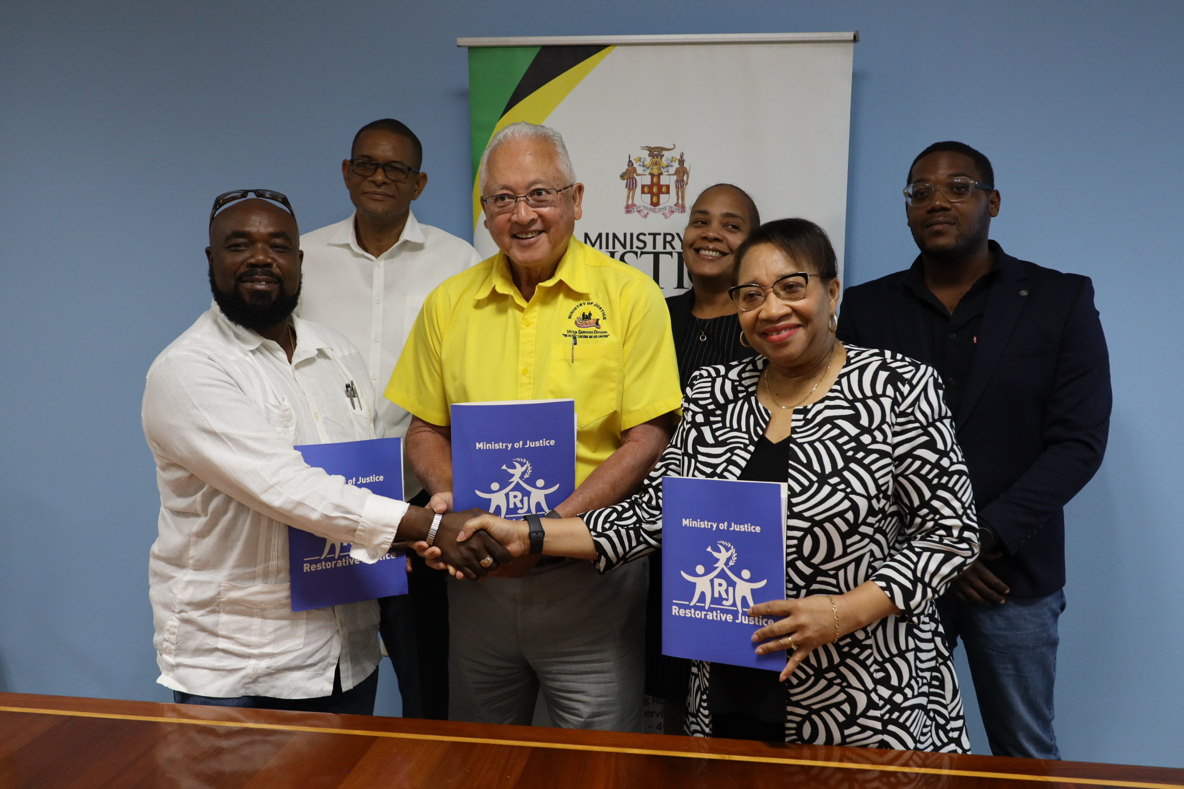 (Front row) Minister of Justice, Hon. Delroy Chuck (centre); Permanent Secretary, Grace Ann Stewart McFarlane (right); and Managing Director of C&D Construction & Engineering Ltd (left) pose with signed contracts for the construction of the Hanover Justice Centre. Looking on are (backrow l-r): Member of Parliament- Hanover Eastern, Dave Brown; Principal Director, Social Justice Division at the Ministry, Jamie Ann Chevannes; and Director, Technical Services at the Ministry, Theodore Mattis.  