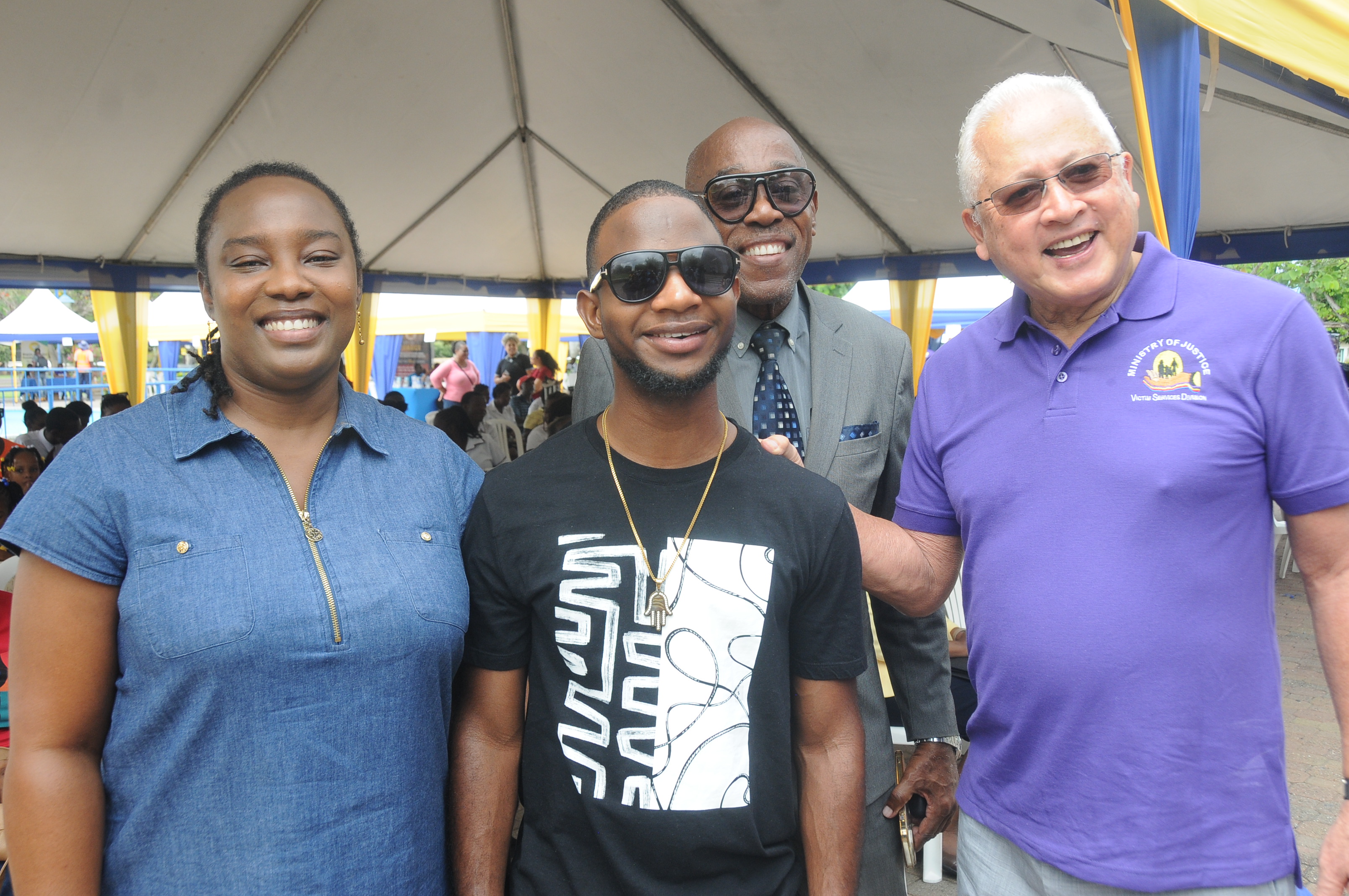 Caption: Nigy Boy, special guest at the LAC Justice Fair for Persons with Disabilities held at the Emancipation Park, is flocked by distinguished guests; Minister of Justice, Hon. Delroy Chuck (right), Custos of Rotulorum for St Andrew, Hon. Ian Forbes (second right) and Kimberley Wilson, Assistant Resident Representative, United Nations Development Programme (UNDP).