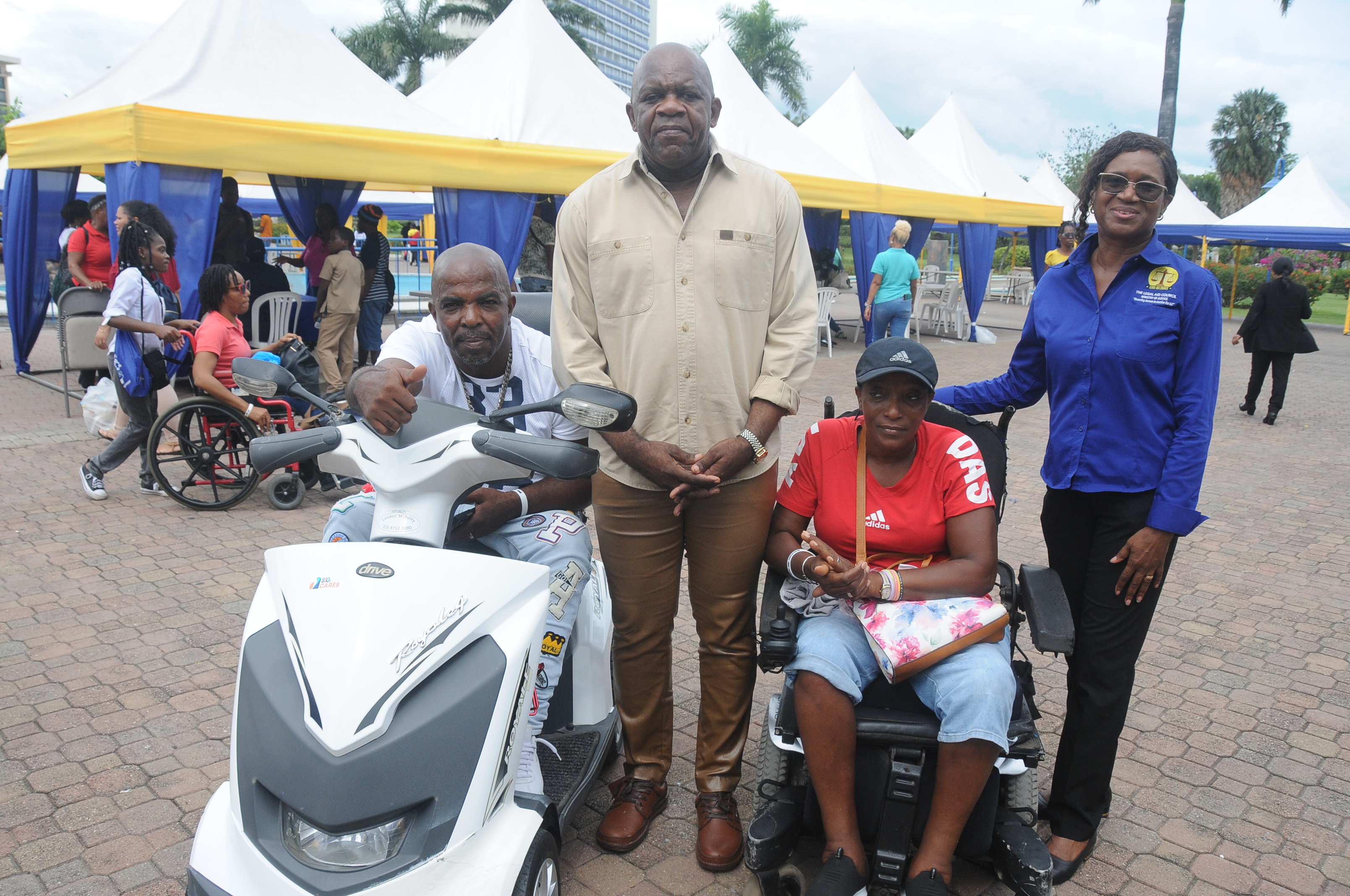 Caption: Sen. Prof Floyd Morris (centre) and Dian Watson, Executive Director of the Legal Aid Council (right) pose with members from the community for persons with disabilities who attended the Fair.